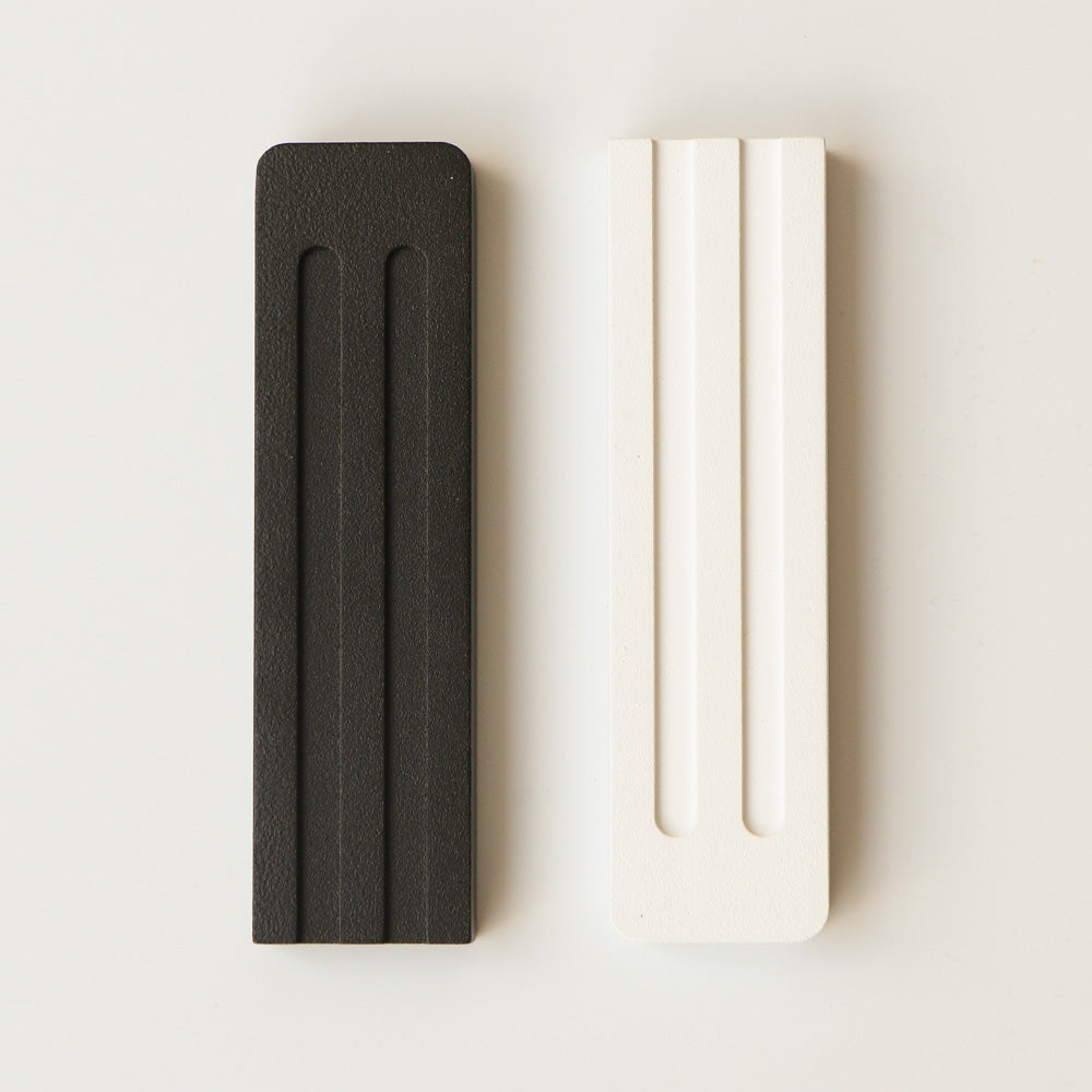 A sleek and refined mezuzah by JUDA that blends modern design with Jewish tradition. Crafted from aluminum using CNC machining and electrostatic painting, it features two clean lines that subtly form the letter Shin (ש). Available in two sizes. A meaningful and aesthetic addition to any doorway.